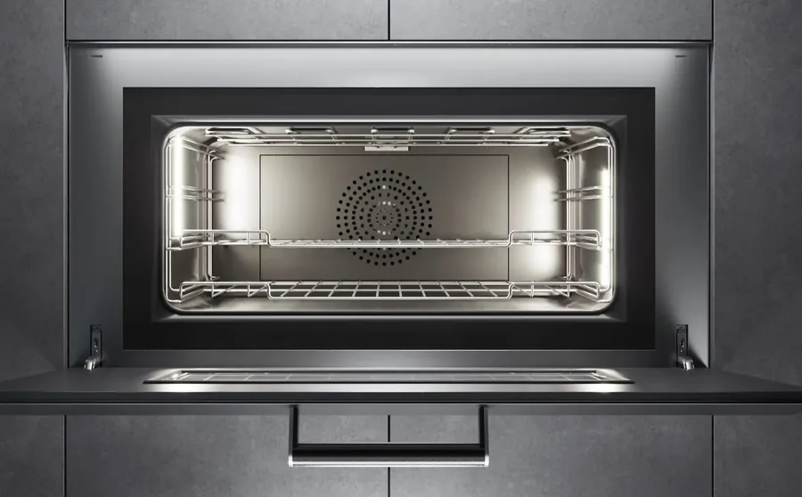 Built-in wall oven with the door down and the empty racks lit